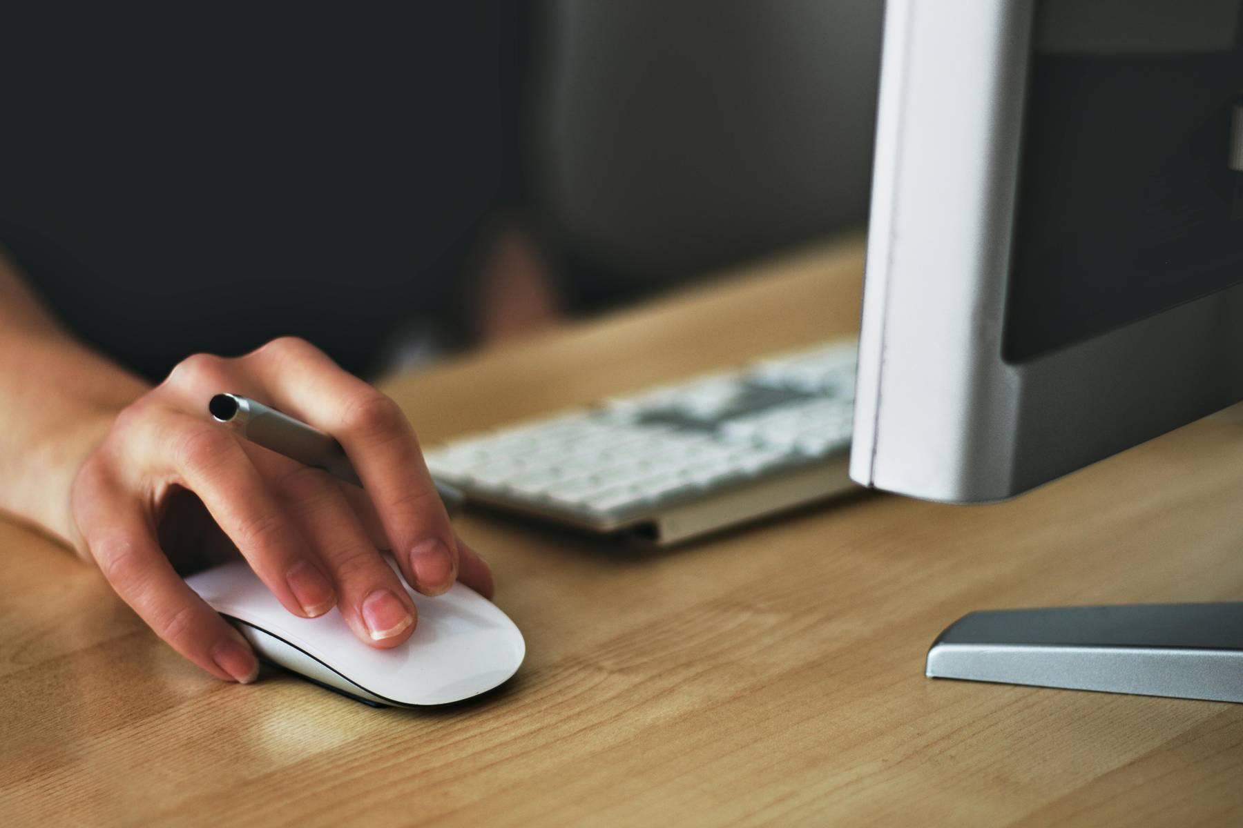 dettaglio di un'impiegata che utilizza il mouse al computer